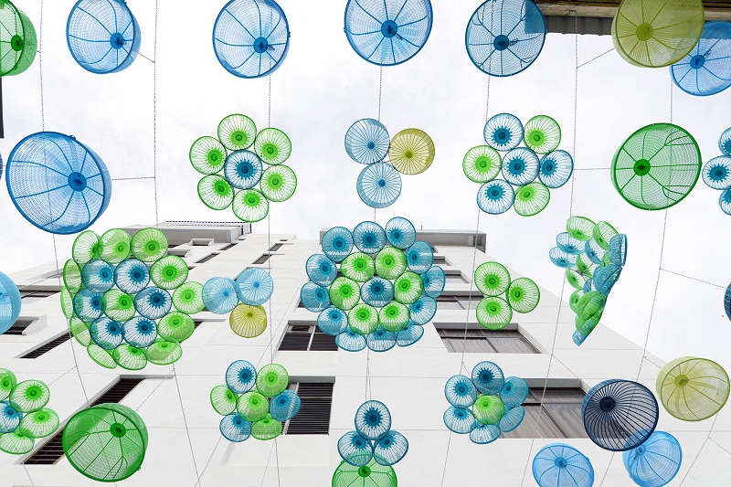 Colourful baskets and colanders strung up along the art alley.