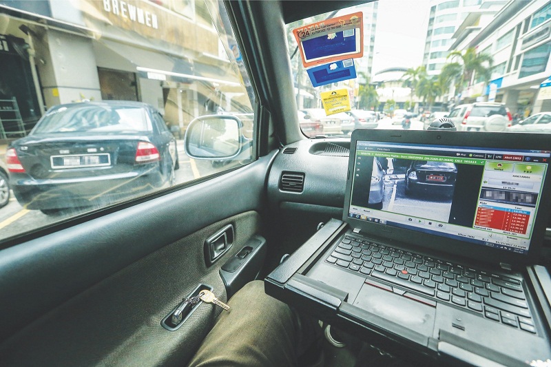 The system on the computer lists the outstanding compounds in red after the scanner runs through the number plate of a car at Solaris Mont Kiara. u00e2u20acu201d Picture by Malay Mail
