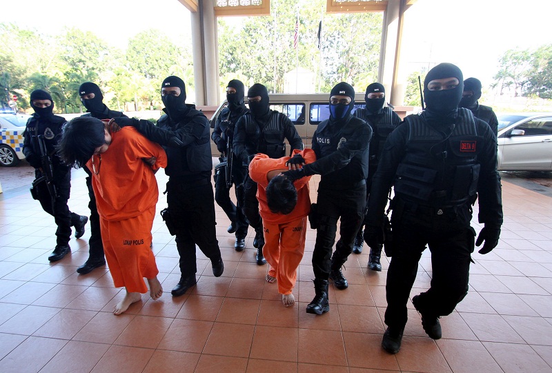 Ang Boon Leong, 39, and Lim Sin Chye, 44, being escorted into the Magistrateu00e2u20acu2122s Court in Kuantan February 17, 2017. u00e2u20acu201d Bernama pic