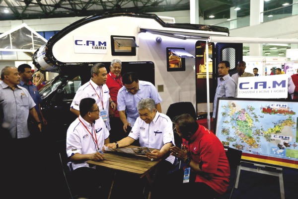 Deputy Prime Minister Datuk Seri Ahmad Zahid Hamidi (centre), MITA president Uzaidi Udanis (right) visit a booth after launching the MITA travel fair at Mines Exhibition Hall, Seri Kembangan. u00e2u20acu201d Picture by Malay Mail