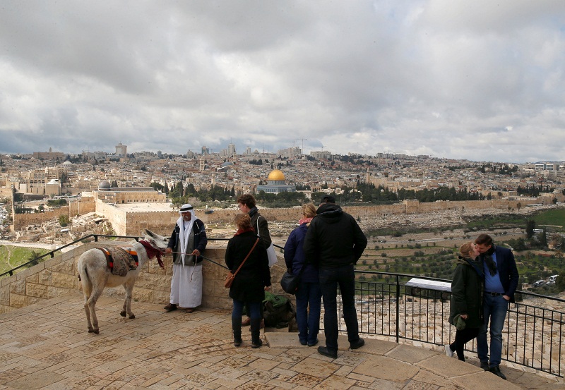 People stand next to a Palestinian man selling donkey rides to tourists, at a lookout point on the Mount of Olives Jerusalem February 27, 2017. u00e2u20acu201d Reuters pic