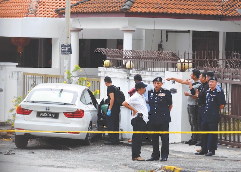 Police personnel carry out investigations at the spot where Lee's car crashed. u00e2u20acu201d Malay Mail pic