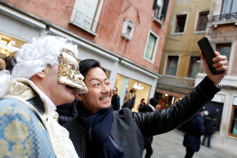 A tourist takes a selfie with a masked reveller during the Venice Carnival in Venice, Italy, February 11, 2017. — Reuters pic