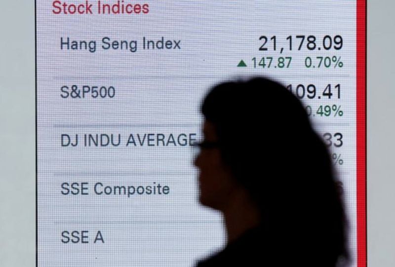 A woman walks past a panel displaying stock indices of Hong Kong, US and China markets, outside a bank in Hong Kong June 7, 2016. u00e2u20acu201d Reuters pic