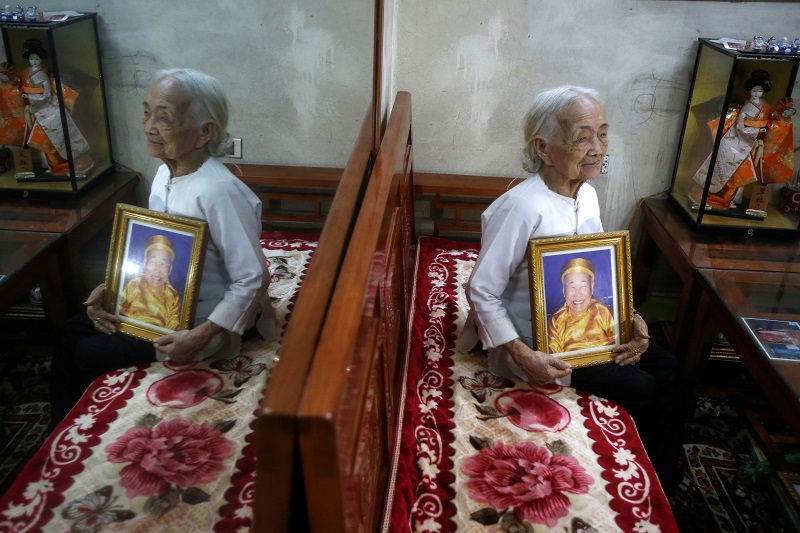Vietnamese Nguyen Thi Xuan, 94, who married Japanese soldier Nguyen Van Duc during World War Two, poses with a portrait of him at her house in Hanoi, Vietnam February 22, 2017. u00e2u20acu201d Reuters pic