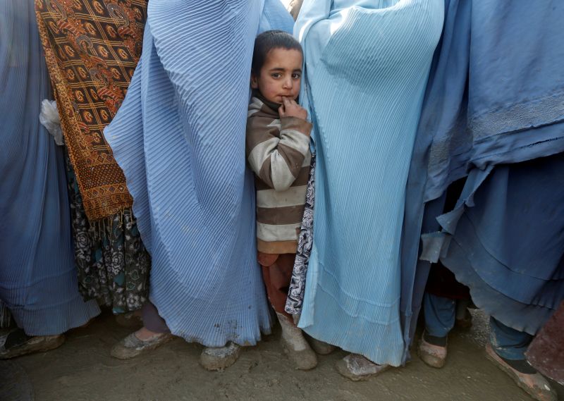 An Afghan boy looks on as internally displaced Afghan women line up to receive winter relief assistance donated by the Islamic Relief program, a non-government organisation, at a refugee camp in Kabul, Afghanistan January 31, 2017. u00e2u20acu201d Reuters pic