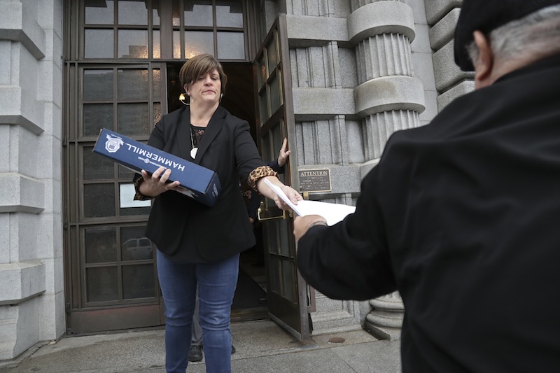 A woman hands out the 9th Circuit Court of Appeals' ruling against President Trump's travel ban, outside the courthouse in San Francisco, February 9, 2017. u00e2u20acu201d NYT pic 