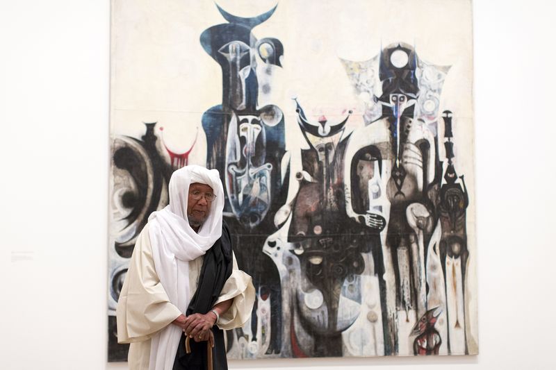Sudanese artist Ibrahim El-Salahi poses for a photograph in front of his painting entitled 'Reborn Sounds of Childhood Dreams' at the Tate Modern in London July 1, 2013. u00e2u20acu201d AFP pic