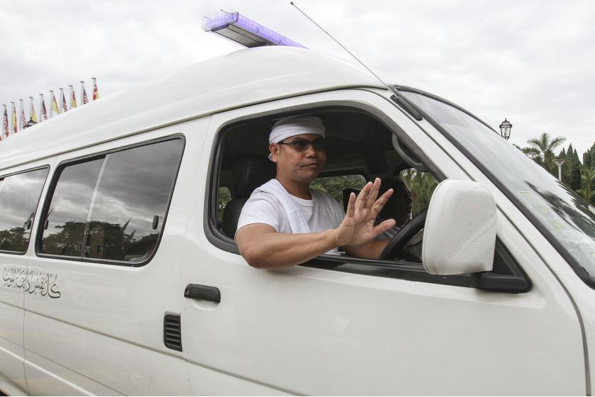 Datuk Seri Jamal Yunos drives a hearse pass the gate of the Selangor state secretariat building. — Picture by Yusof Mat Isa