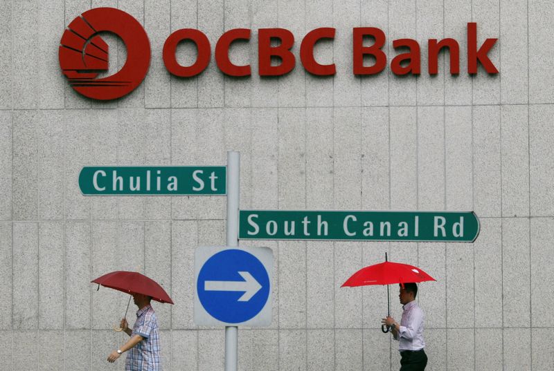 Office workers pass an Oversea-Chinese Banking Corp building in the central business district of Singapore January 6, 2014. u00e2u20acu201d Reuters pic
