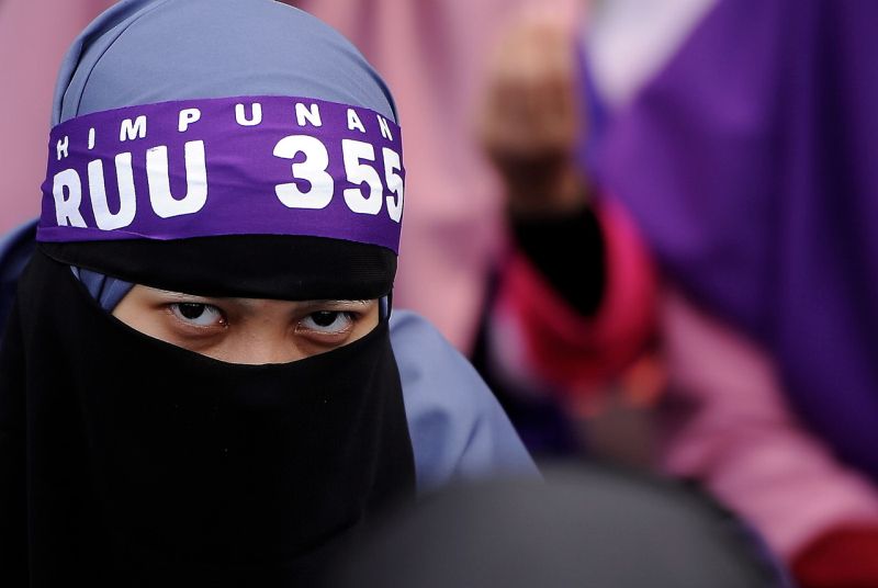 Seorang wanita tekun mendengar ucapan pada Himpunan Rang Undang-Undang (RUU) 355 anjuran Pas di Padang Merbok hari ini. u00e2u20acu2022 Foto Bernama