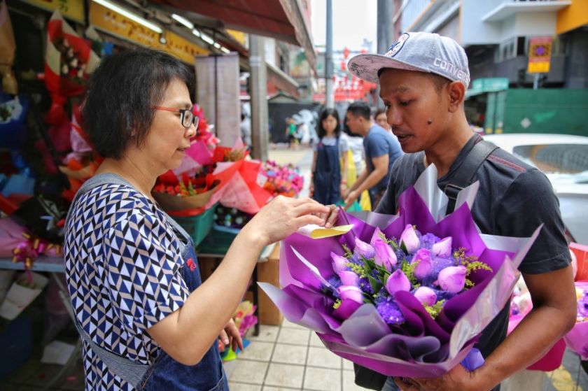 A worker at a florist on Petaling Street, Kuala Lumpur gets ready to deliver flowers ahead of Valentine's Day on February 13, 2017. u00e2u20acu201d Picture by Saw Siow Feng