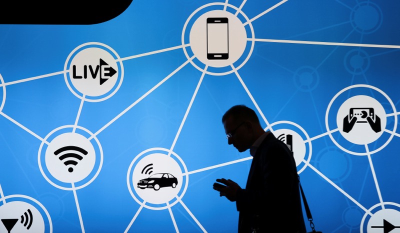 A man looks at his phone in front of a stand at the Mobile World Congress in Barcelona, Spain, February 28, 2017. u00e2u20acu201d Reuters pic