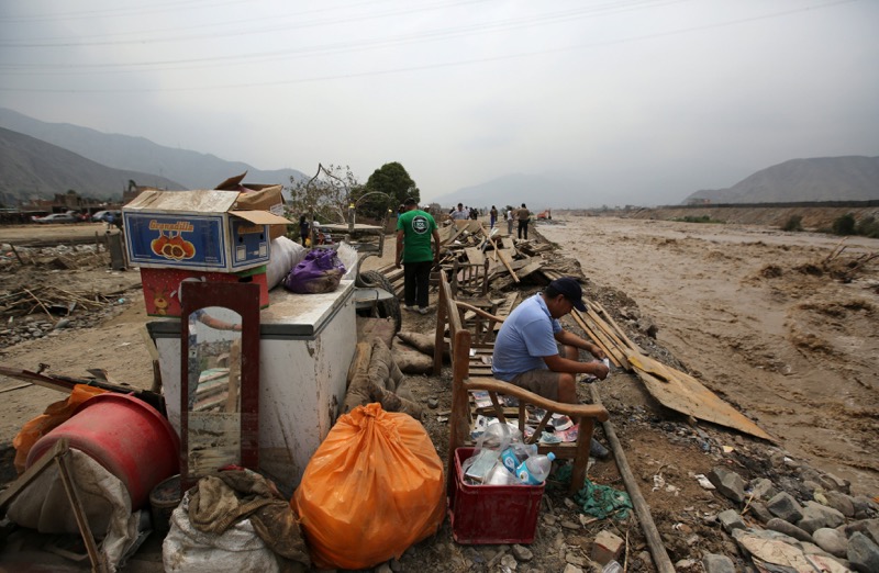 A man sits with his belongings, after rivers breached their banks due to torrential rains, causing flooding and widespread destruction in Huachipa, Lima, Peru, March 19, 2017. u00e2u20acu201d Reuters pic