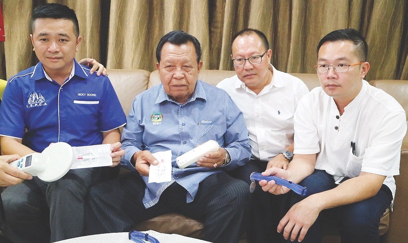 Ipoh Society for Prevention of Cruelty to Animals president Ricky Soong (left) showing the microchips that will be inserted into stray dogs that have been neutered or spayed. u00e2u20acu201d Picture by Malay Mail