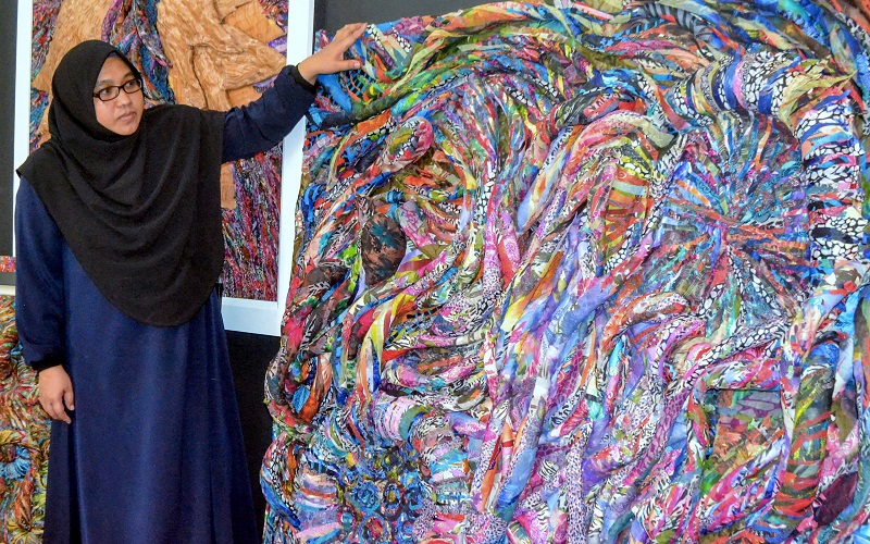 Stu Ben Artworkshop owner Wan Jaida Wan Samidin, 41, poses next to one of her masterpieces created using remnants or small pieces of cloths, in Pasir Puteh March 18, 2017. u00e2u20acu201d Reuters pic