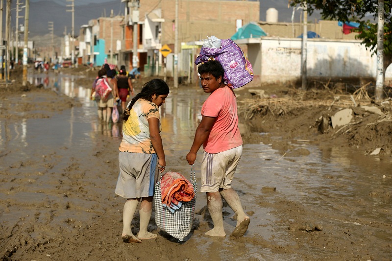 Residents cross a flooded street, after rivers breached their banks due to torrential rains, causing flooding and widespread destruction in Huarmey, Ancash, Peru March 22, 2017. u00e2u20acu201d Reuters pic