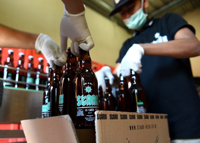 This picture taken on February 24, 2017 shows workers packing bottles of beer into boxes at the Stark Beer factory in Singaraja, a regency on Indonesia's Bali island.u00c2u00a0u00e2u20acu201d AFP pic