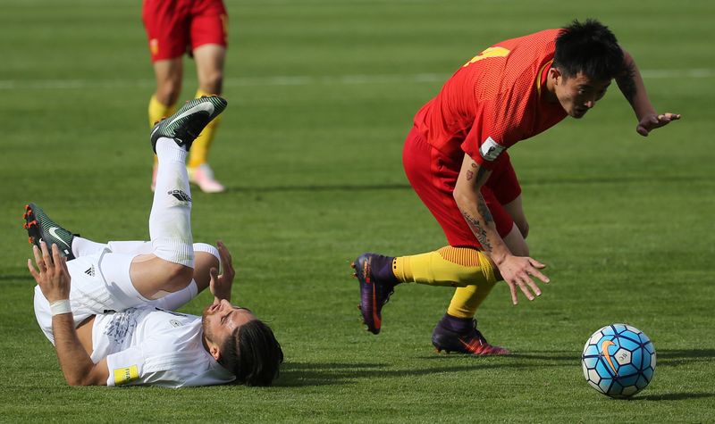 Chinau00e2u20acu2122s Jiang Zhipeng (left) fights for the ball during the 2018 World Cup qualifying football match between Iran and China at the Azadi Stadium in Tehran on March 28, 2017. u00e2u20acu201d AFP pic