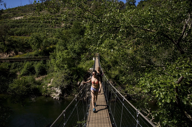 A woman crosses a suspension bridge over the Paiva River, part of the five-mile Paiva Walkways, promenade which opened in 2015 in Arouca, Portugal, May 20, 2016.