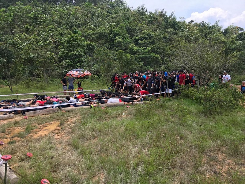 Racers waiting for their turn to get down and dirty at the mud crawl obstacle.