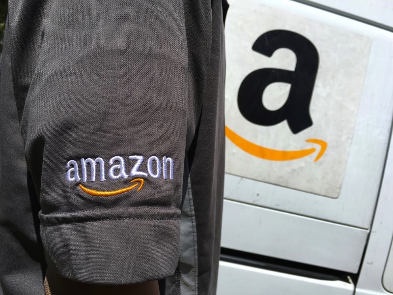 An Amazon.com Inc driver stands next to an Amazon delivery truck in Los Angeles, May 21, 2016. u00e2u20acu201d Reuters pic