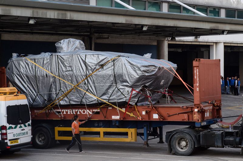 A worker walking past an impounded tarpaulin-covered armoured troop carrier Terrex vehicle belonging to the Singapore military in Hong Kong January 26, 2017. u00e2u20acu201d AFP pic