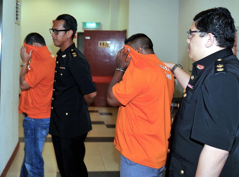 A police officer (left) who served in the Gombak district police headquarters and a Bangladeshi man (right) were remanded for seven days to facilitate investigations into a case of soliciting and accepting a bribe. u00e2u20acu201d Bernama pic