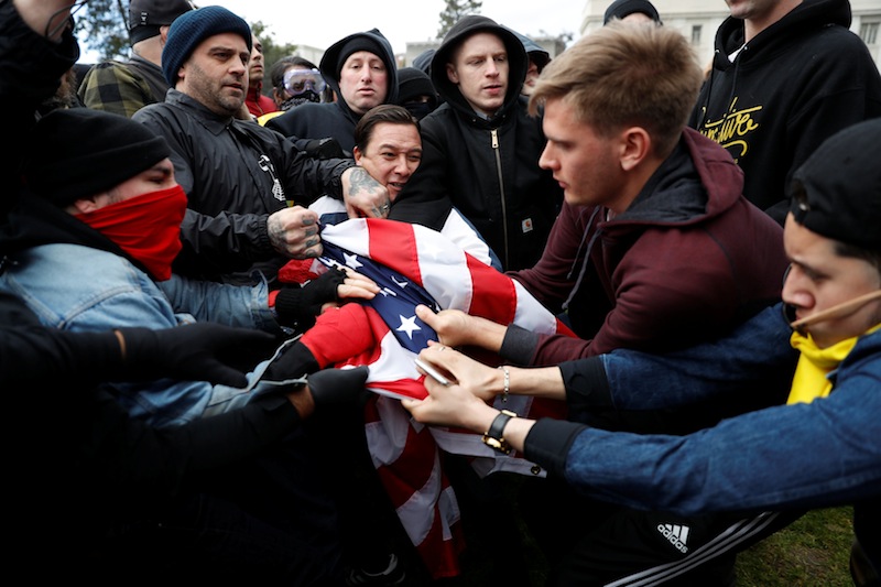 Counter-demonstrators (left) and supporters (right) of US President Donald Trump fight for a US flag during a 'People 4 Trump' rally in Berkeley, California March 4, 2017. u00e2u20acu201d Reuters pic