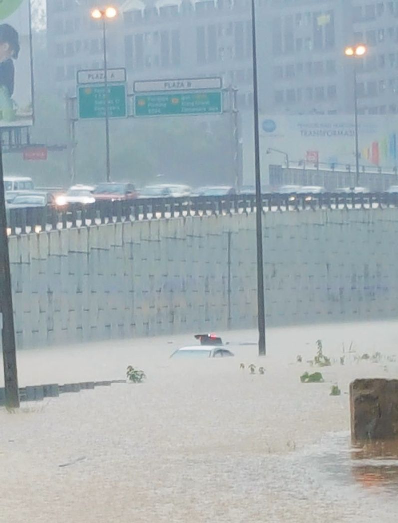 Siti Hajaru00e2u20acu2122s car almost fully submerged in flood water on the Sprint Highway on Tuesday evening. u00e2u20acu2022 Malay Mail pic