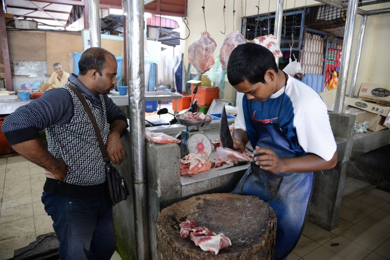 Mohd Faiz Md Nasir chopping up some mutton for a customer.