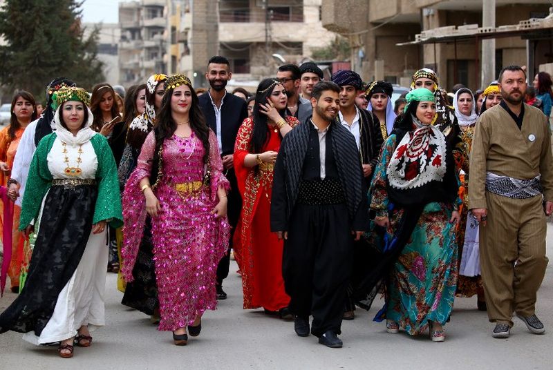 Syrian-Kurdish men and women model traditional Kurdish attire during a fashion show in the northeastern Syrian city of Qamishli.