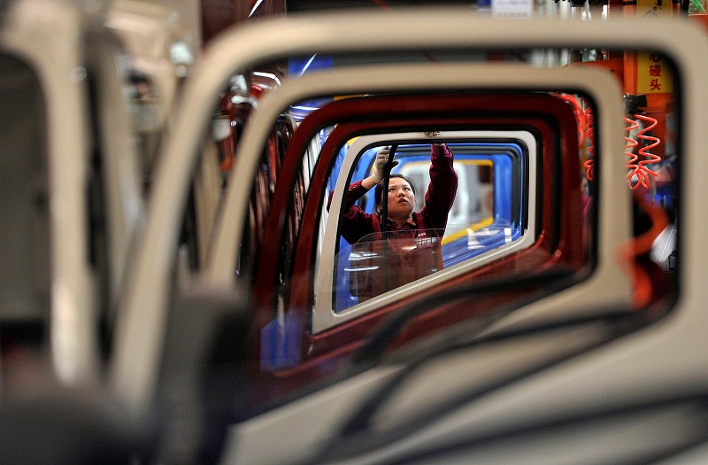 A worker installs rubber onto the windows of the doors along a production line at a truck factory of Anhui Jianghuai Automobile Co Ltd (JAC Motors) in Hefei, Anhui province May 5, 2014. u00e2u20acu201d Reuters pic