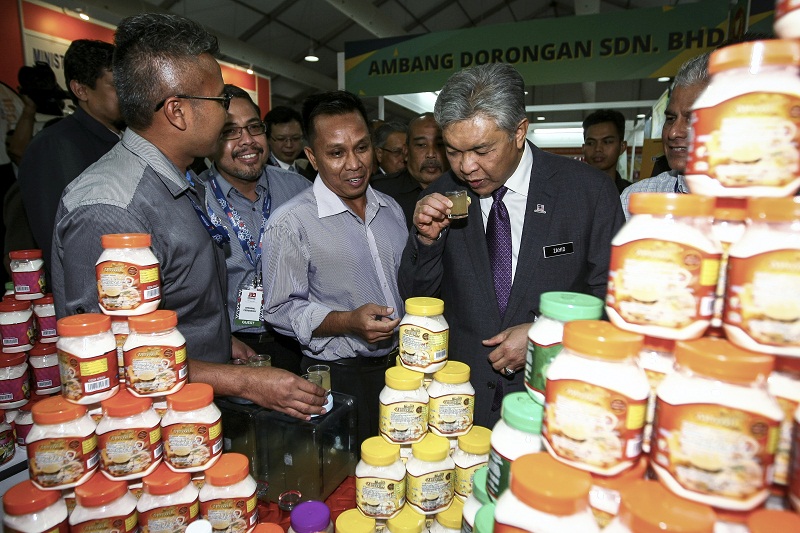Deputy Prime Minister Datuk Seri Ahmad Zahid Hamidi (right) tries some locally made ginger honey during his visit to the Malaysia International Halal Showcase 2017 in Kuala Lumpur. Picture released April 6, 2017. u00e2u20acu201d Reuters pic
