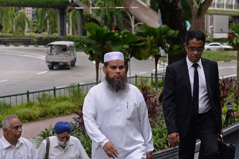 Imam Nalla Mohamed Abdul Jameel (centre), who made offensive remarks against Jews and Christians, at the State Courts with his lawyer (right). u00e2u20acu201d TODAY pic