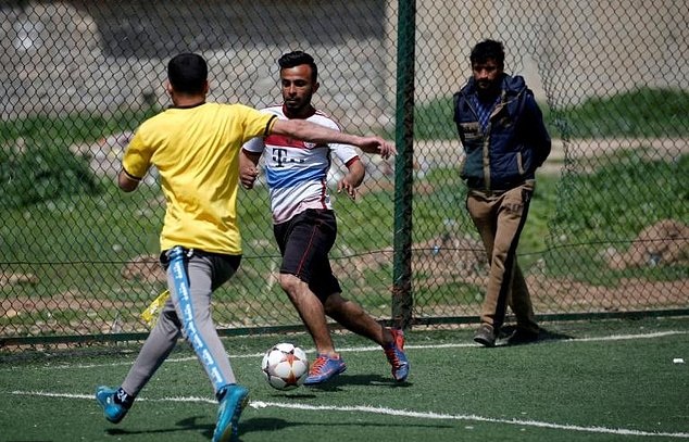 An Iraqi player (centre), sporting the jersey of German club Bayern Munich, dribbles past a defender during a football match in eastern Mosulu00e2u20acu2122s al-Salam neighbourhood on April 7, 2017. u00e2u20acu201d AFP pic