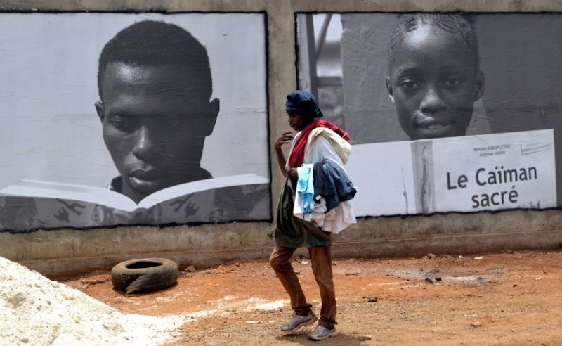 A person walks past posters promoting the u00e2u20acu02dcConakry u00e2u20acu201c 2017 World book capitalu00e2u20acu2122 event organised by the United Nations Educational, Scientific and Cultural Organisation (Unesco) in Conakry on April 23, 2017.u00c2u00a0u00e2u20acu201d AFP pic