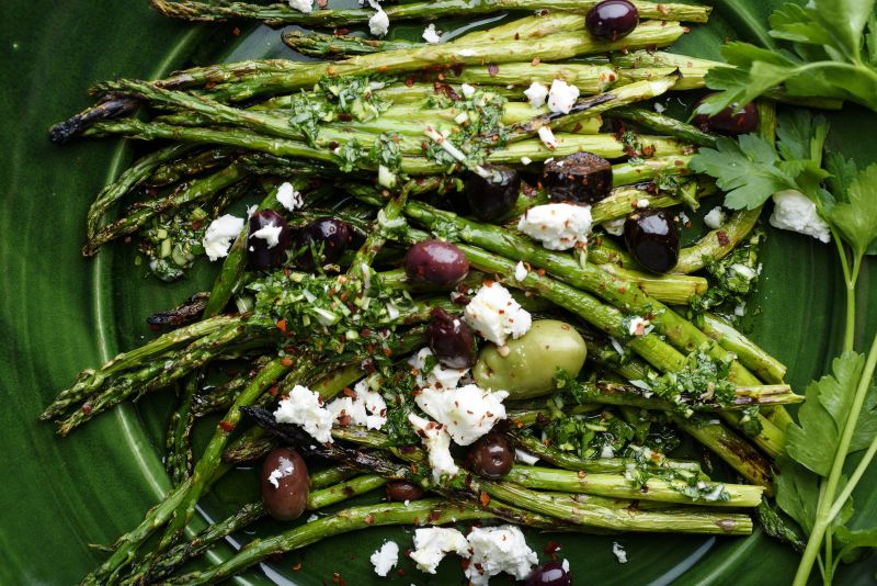 Charred asparagus with green garlic chimichurri, topped with red pepper, feta and olives. u00e2u20acu2022 Picture by Karsten Moran/The New York Times