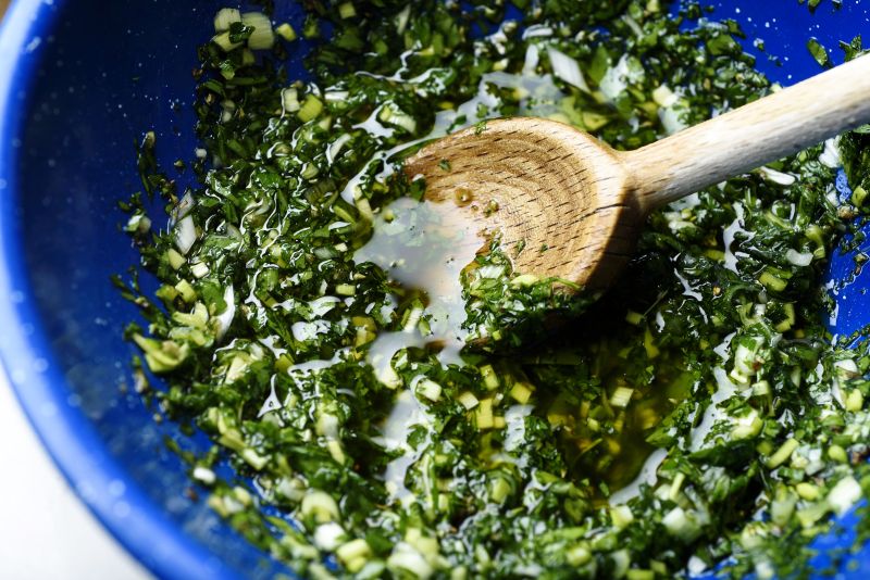 The herb sauce is stirred for charred asparagus with green garlic chimichurri.