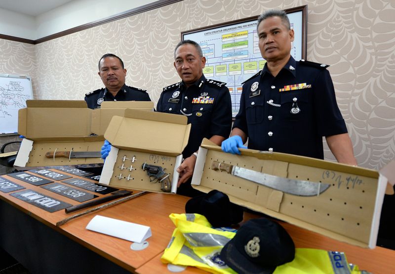 Acting Perak police chief Datuk Hasnan Hassan (centre) and his officers showing the pistol revolver and machetes used by the u00e2u20acu02dcMamak Gangu00e2u20acu2122 members, during a press conference in Ipoh, April 5, 2017. u00e2u20acu201d Bernama pic