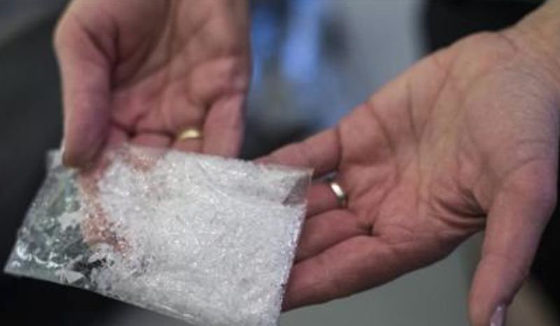 A customs officer holds a bag of the drug methamphetamine confiscated at the German border, before a news conference presenting the annual report of Germany's customs agency, Zoll, at the finance ministry in Berlin, March 22, 2013. REUTERS