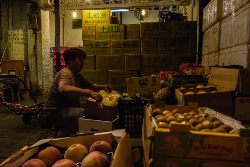 In this photo taken before daybreak on March 16, 2017, a wholesale fruit vendor prepares a box of fruit at the wholesale Yau Ma Tei fruit market in the Kowloon district of Hong Kong. u00e2u20acu201d AFP pic