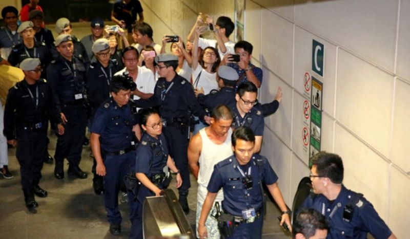 An unattended bag caused a security scare yesterday, leading to the closure of Hougang MRT Station for more than an hour. A 39-year-old man (in white singlet) was arrested for causing a public alarm, under the offence of Public Nuisance in the Penal Code.