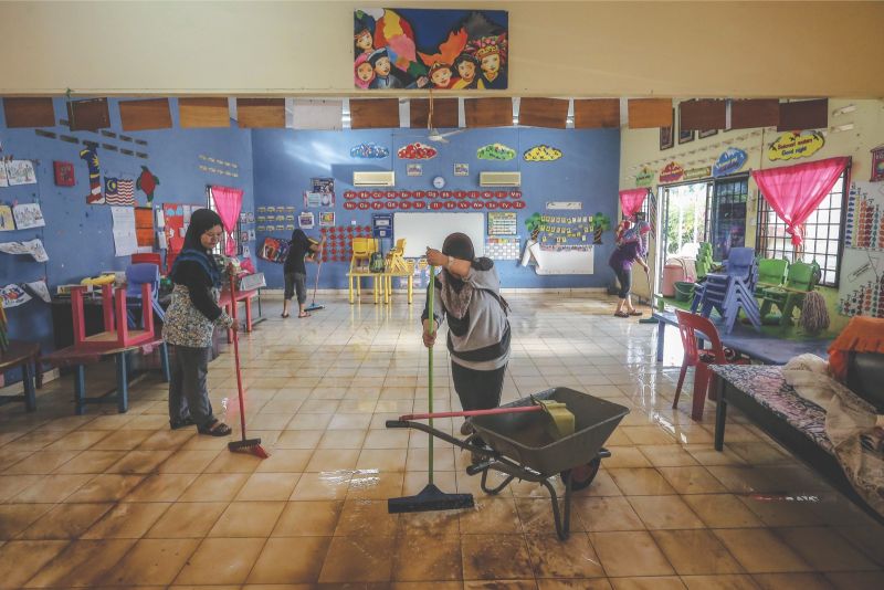 Teachers and parents of  Tadika Kemas in Hulu Kelang clear the water from Tuesdayu00e2u20acu2122s flash floods. u00e2u20acu201d Picture by Firdaus Latif