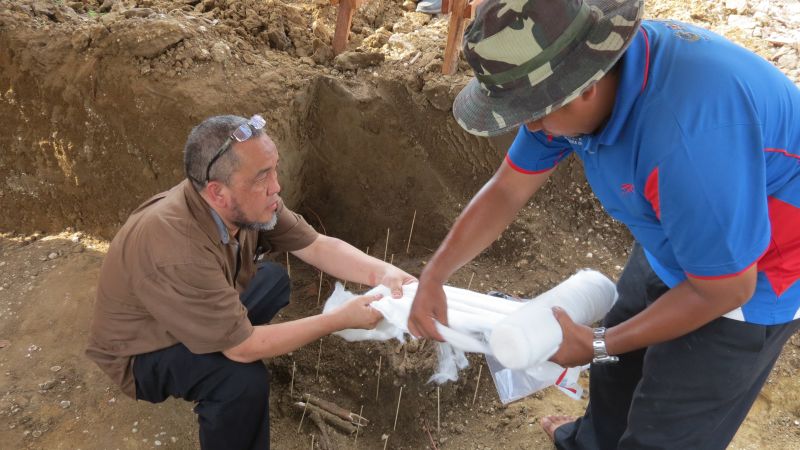 Prof Datuk Mokhtar Saidin (left) at the excavation site in Guar Kepah after the discovery of the skeleton.