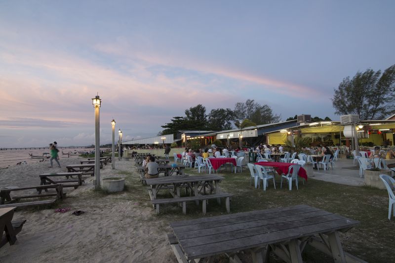 Patrons enjoy a scenic view of sunset along Pantai Bersih. — Picture by KE Ooi