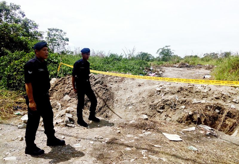 Two police personnel stand on guard at the entrance of a plot of land in Bukit Aup in Sibu where a few containers of frozen chicken wings have been disposed, to prevent members of the public from entering the area, April 5, 2017. u00e2u20acu201d Bernama pic