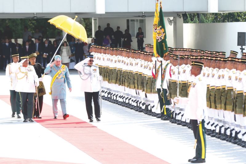 Yahya carries the royal umbrella as Sultan Muhammad V inspects a guard of honour at the opening of the new Parliament session in Kuala Lumpur on March 6. u00e2u20acu201d Picture by Ahmad Zamzahuri 