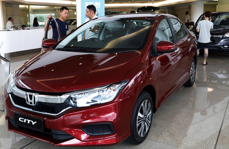 A prospective buyer talks to a salesman at a car showroom in Johor Baru May 8, 2017. u00e2u20acu201d Reuters pic