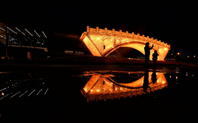 People take pictures in front of a u00e2u20acu02dcGolden Bridge on Silk Roadu00e2u20acu2122 installation, set up ahead of the Belt and Road Forum, outside the National Convention Centre in Beijing May 11, 2017. u00e2u20acu201d Reuters pic
